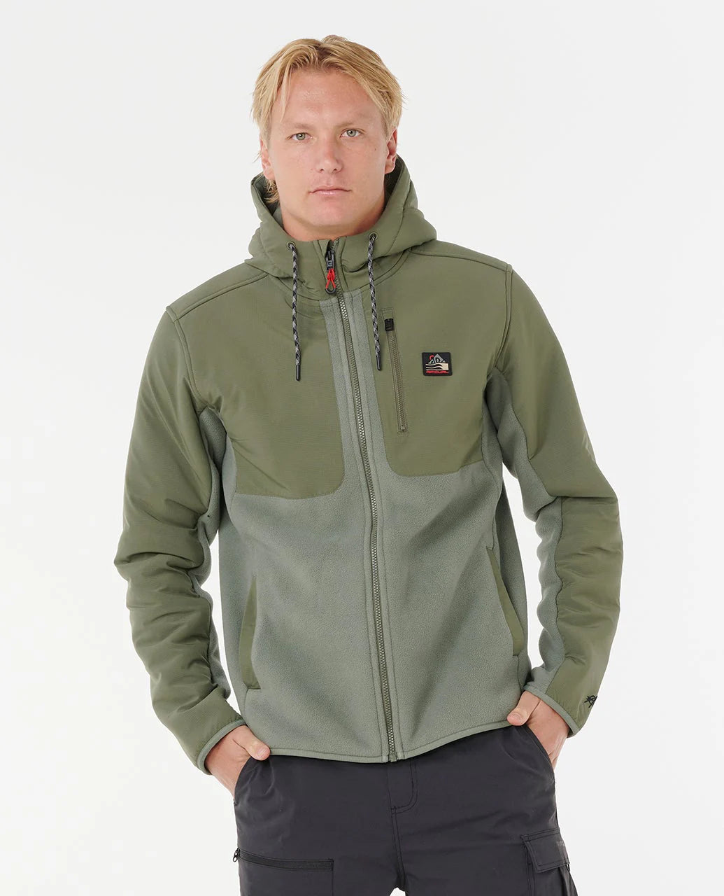 Man wearing a rip curl anti series fleece green jacket with a hood on a white background