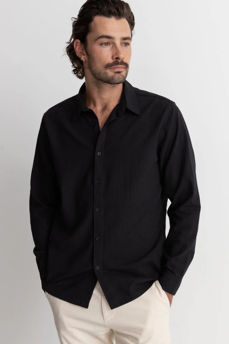 Man wearing rhythm classic linen long sleeve shirt in black against white background