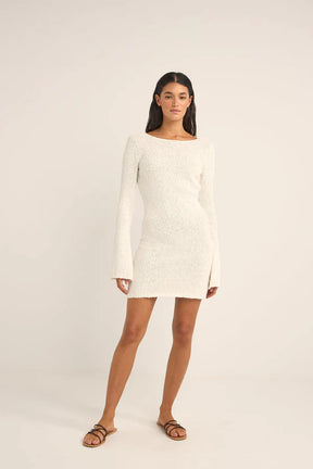 Woman wearing the rhythm adele long sleeve knit dress against a white background