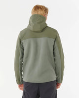 Person wearing a rip curl anti series fleece green jacket with a hood on a white background