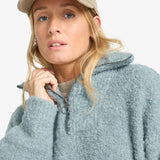 Person wearing a light blue hoodie and beige cap on a white background