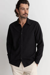 Man wearing rhythm classic linen long sleeve shirt in black against white background