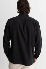 The back of a man wearing a rhythm classic linen long sleeve shirt in black