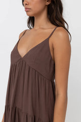 Woman wearing a rhythm chocolate tiered maxi dress with thin straps against a white background