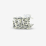 White hair clip with black polka dot pattern on a white background