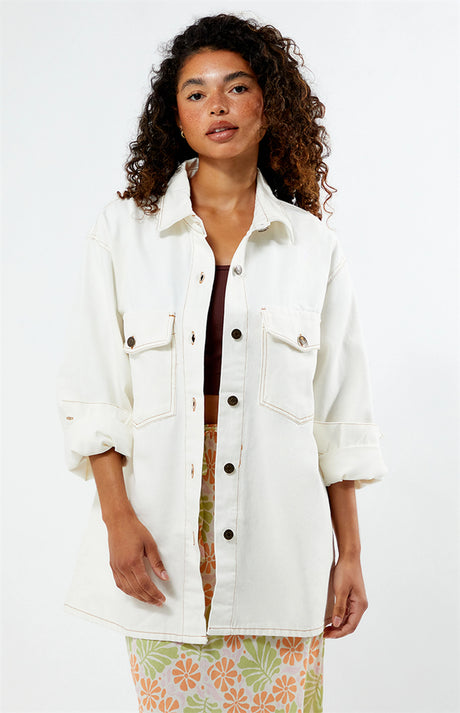 Woman wearing a rhythm camilla oversized white denim jacket on a white background