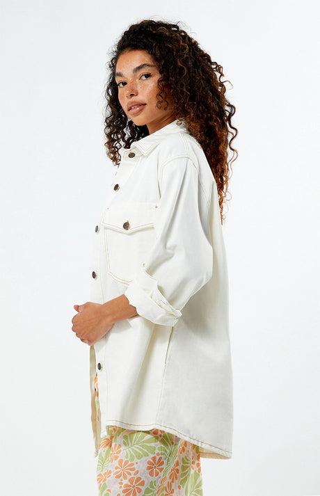 Woman wearing a rhythm camilla oversized white jacket on a plain background