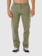 Man wearing rip curl classic surf chino cactus green pants on a white background