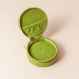 inside the cai and jo Green jewelry box with a gold zipper on a beige background
