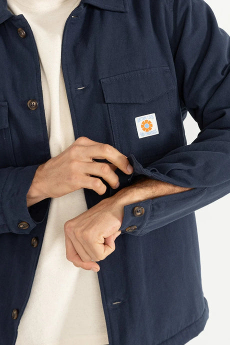 close up of a mans writst unbuttoning the rhythm sherpa lined workshirt