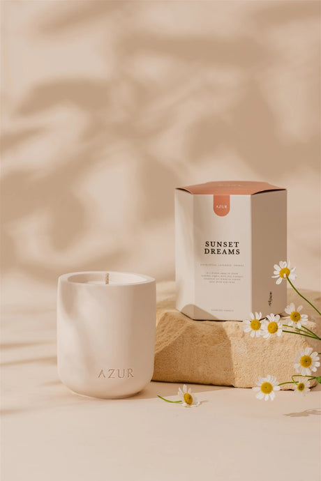 Ceramic candle with 'AZUR' branding and a box labeled 'Sunset Dreams' on a beige background.