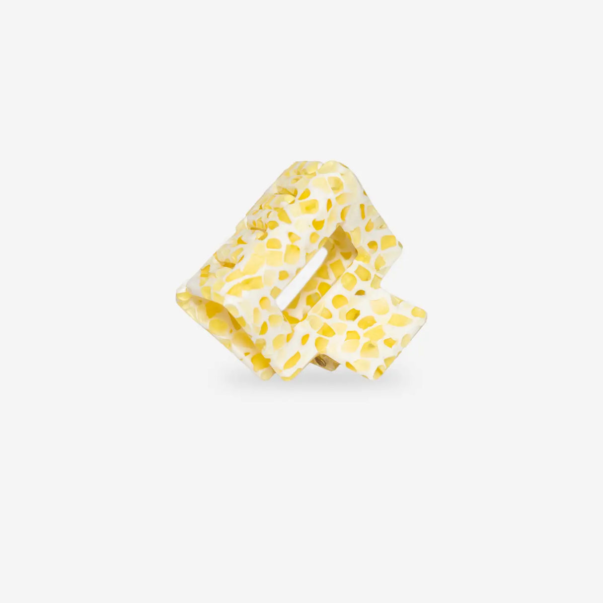 Yellow polka dot hair clip on a white background