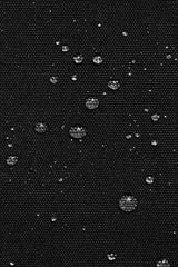 Water droplets on a black textured surface, waterproof backpack