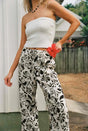woman wearing rhythm top and sundance drawstring pant holding a hibiscus flower