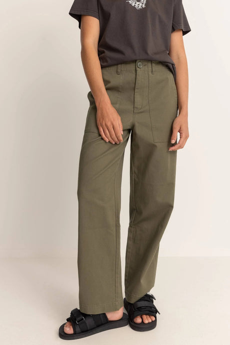 Woman wearing rhythm fatige olive green pants and a black shirt on a beige background